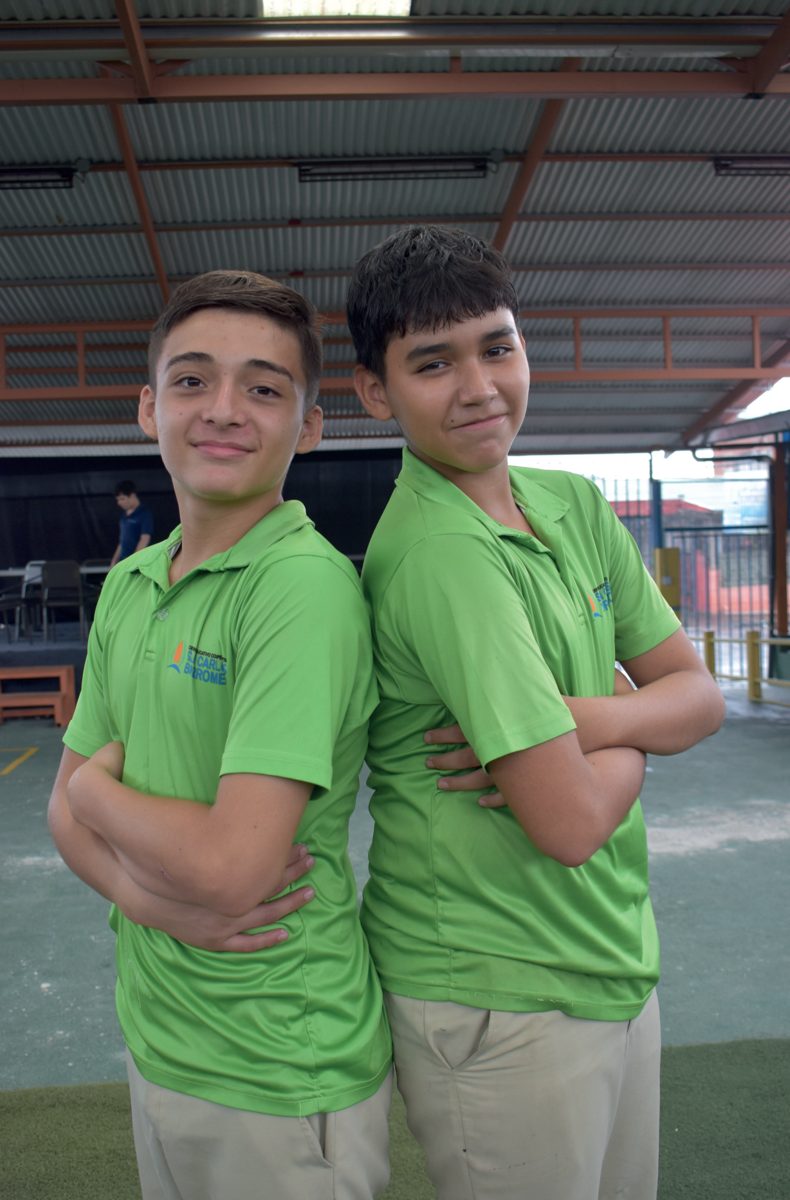 Dos estudiantes del colegio con uniforme verde